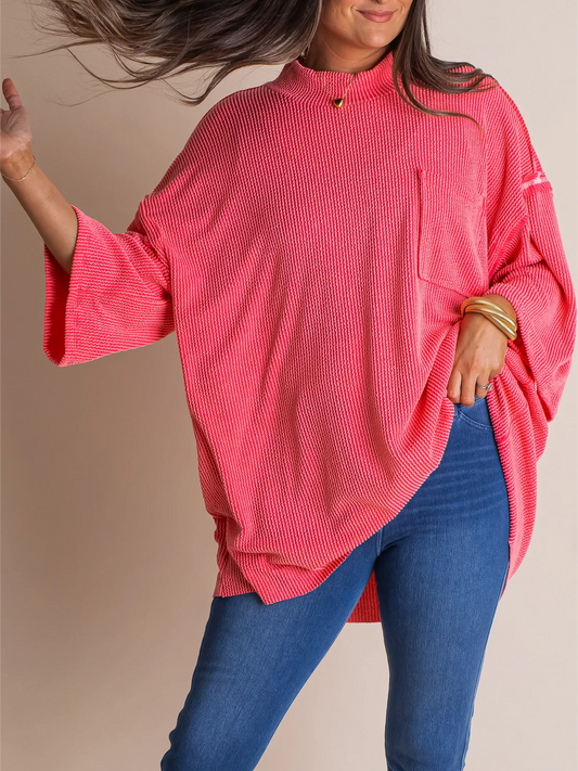 Oversize high neck urban ribbed tunic in pink with exposed seams and oversized pocket, styled with blue jeans.